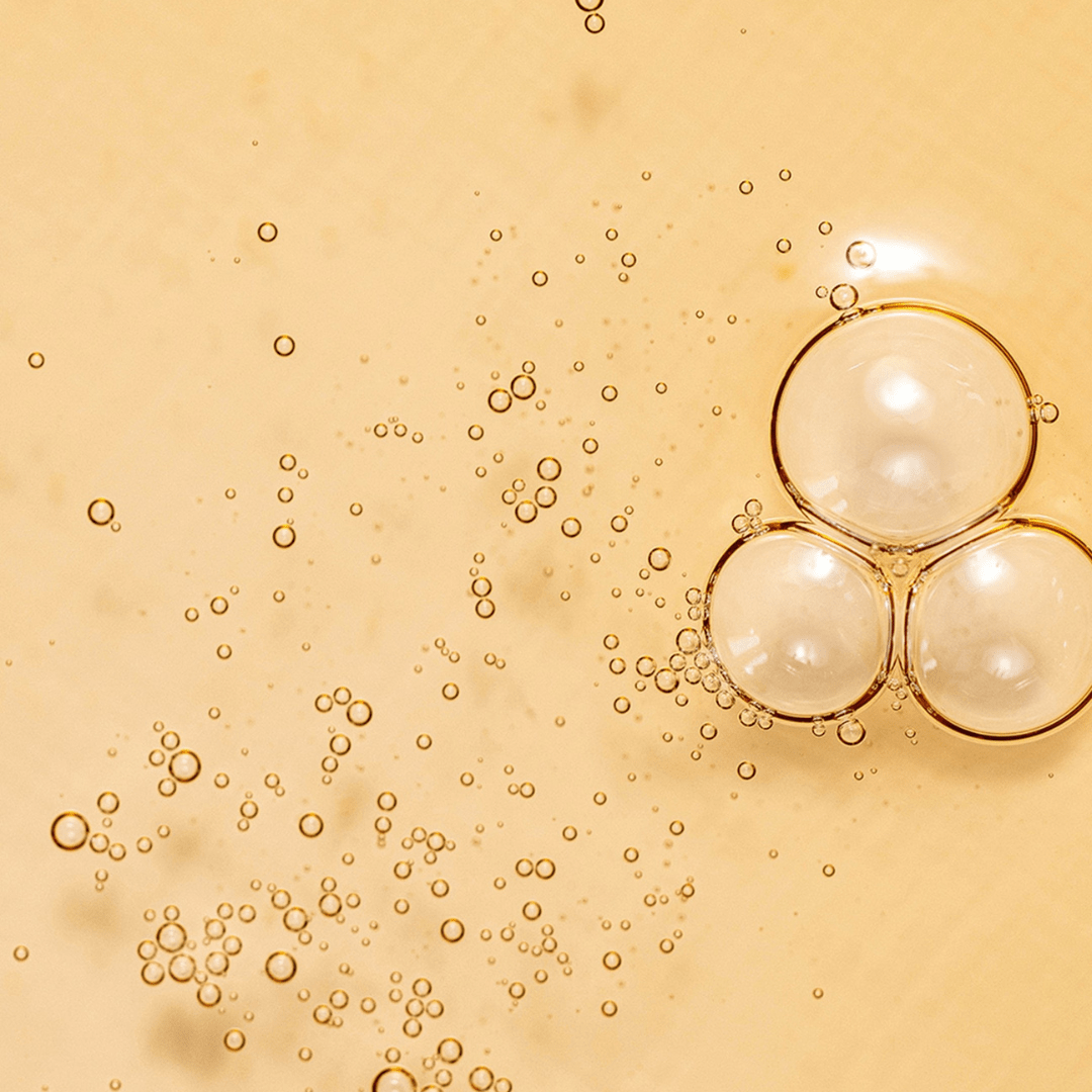 Close-up texture shot of Ginseng Essence Water with bubbles – This K-Beauty is rich in antioxidants for skin vitality.