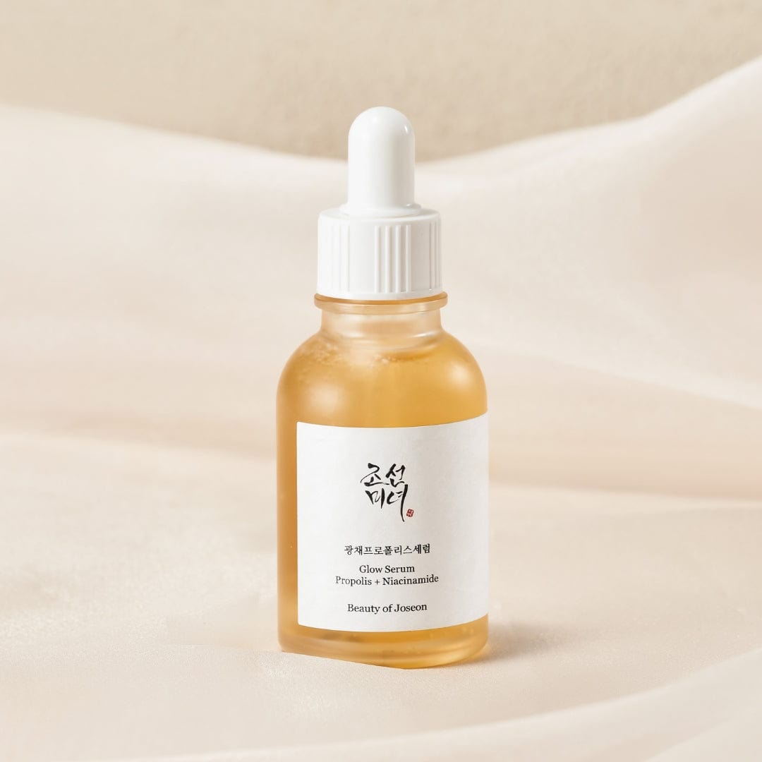 Beauty of Joseon Glow Serum Propolis & Niacinamide bottle close-up on soft fabric with label in clear focus at K-Beau.