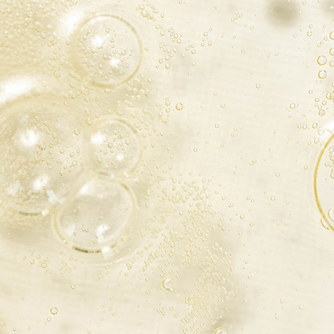 Close-up macro of Beauty of Joseon Glow Serum Propolis & Niacinamide with golden K-Beauty propolis bubbles suspended in serum.