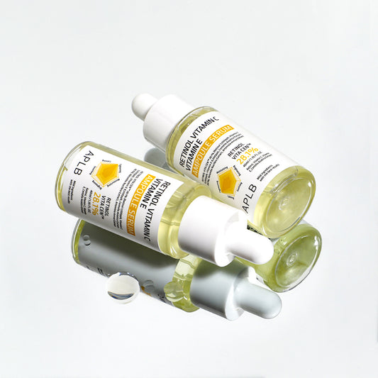 Two APLB Retinol Vitamin C Vitamin E Ampoule Serum bottles arranged with a reflective skincare styling effect.