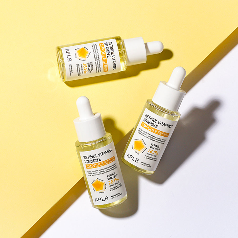 Three APLB Retinol Vitamin C Vitamin E Ampoule Serum bottles styled across yellow and white backgrounds.