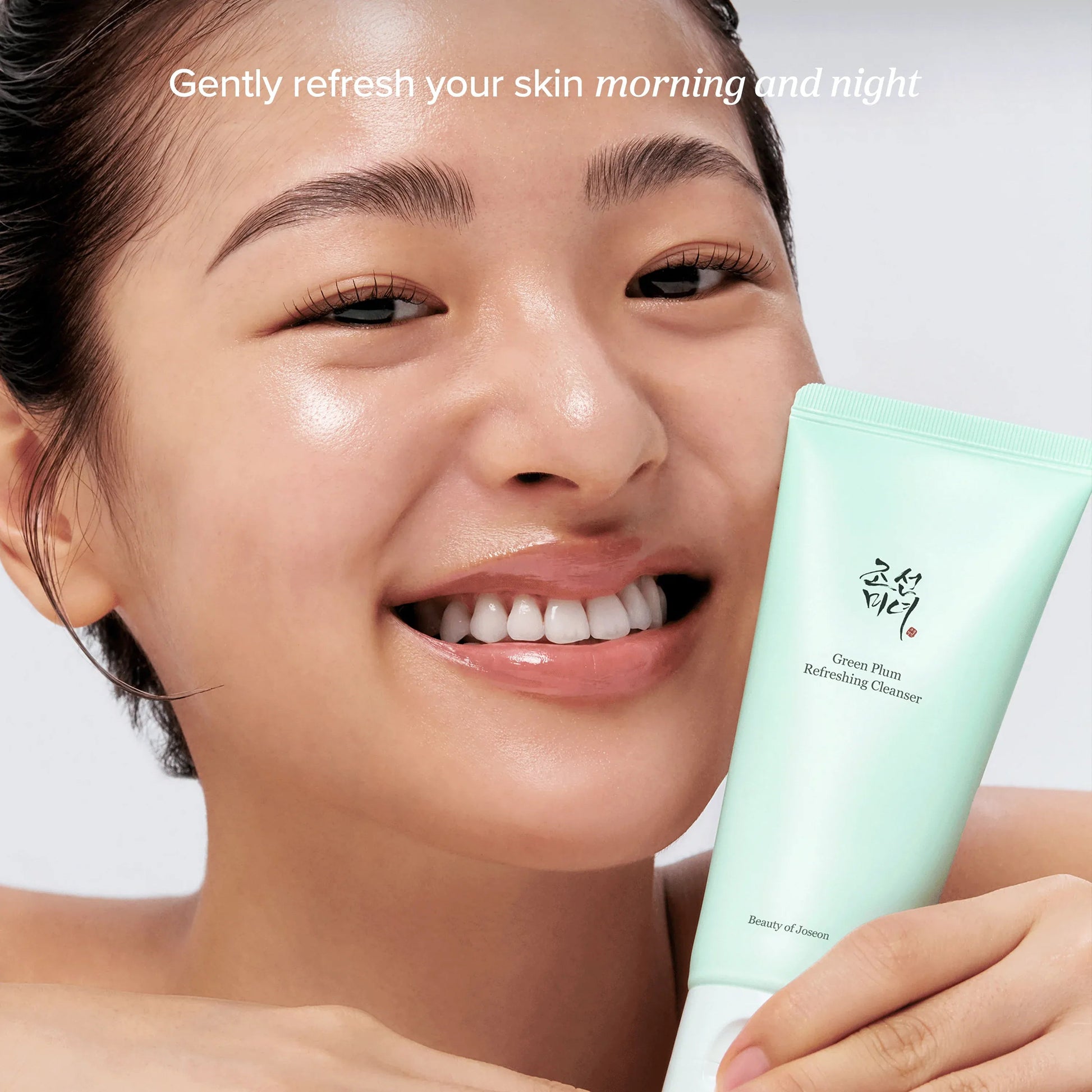 Model holding Beauty of Joseon Green Plum Refreshing Cleanser, a gentle K-beauty facial cleanser for morning and night that helps refresh skin without stripping moisture.