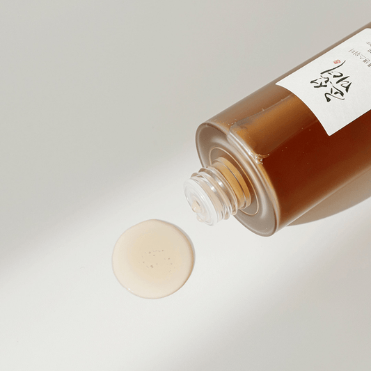 Essence water pouring flatlay – hydrating formula with ginseng for brightening & revitalizing skin. 