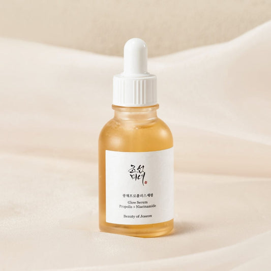 Beauty of Joseon Glow Serum Propolis & Niacinamide bottle close-up on soft fabric with label in clear focus at K-Beau.